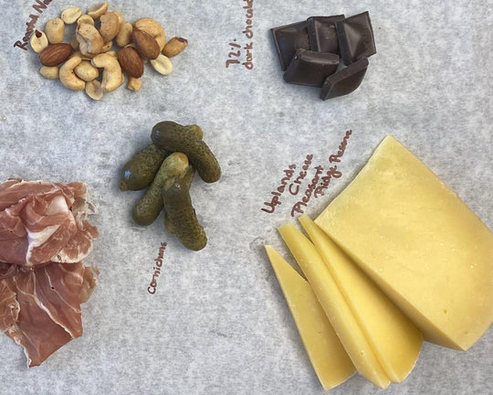 cornichon pickles and cheese with prosciutto, nuts and chocolate